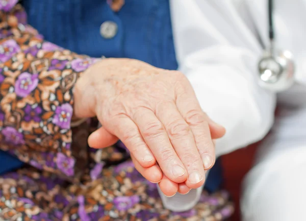 Zoete jonge dokter houdt de oude vrouw — Stockfoto