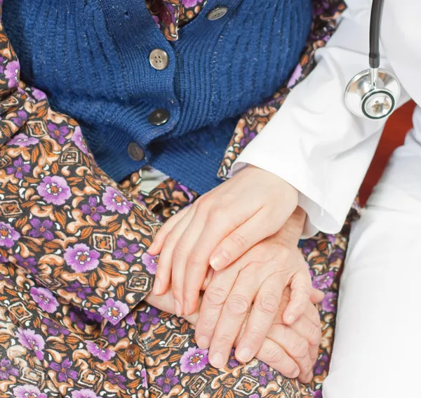 Jeune médecin doux tient la vieille femme — Photo