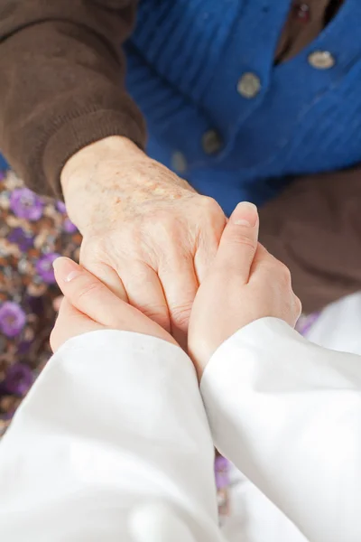 Young sweet doctor holds the old woman — Stock Photo, Image