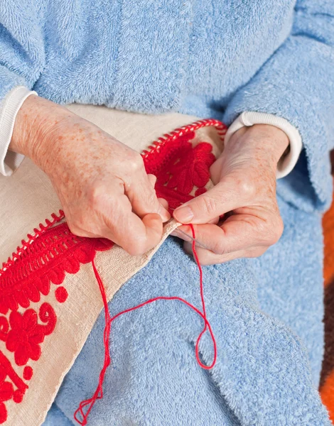 Old woman sews — Stock Photo, Image