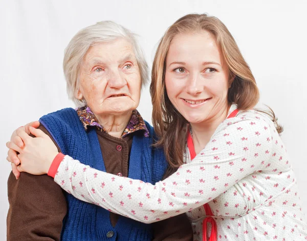 The sweet young girl and the old woman staying together — Stock Photo, Image