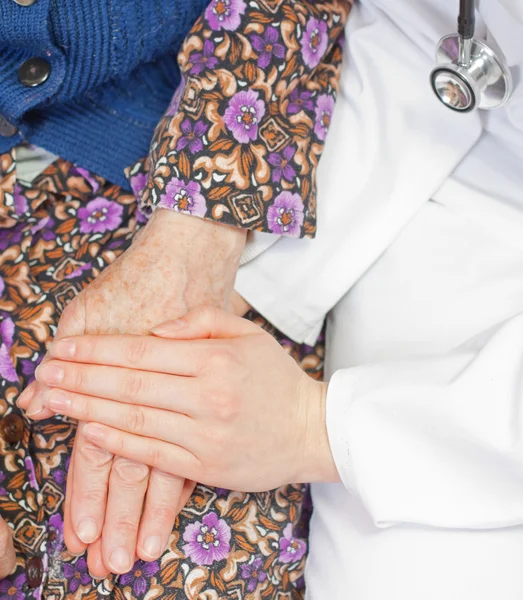 Yaşlı kadın genç tatlı doktor tutar — Stok fotoğraf