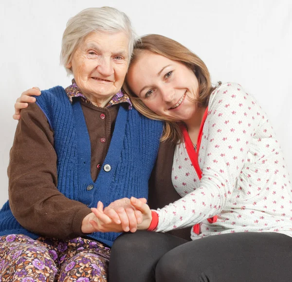 The sweet young girl and the old woman staying together — Stock Photo, Image