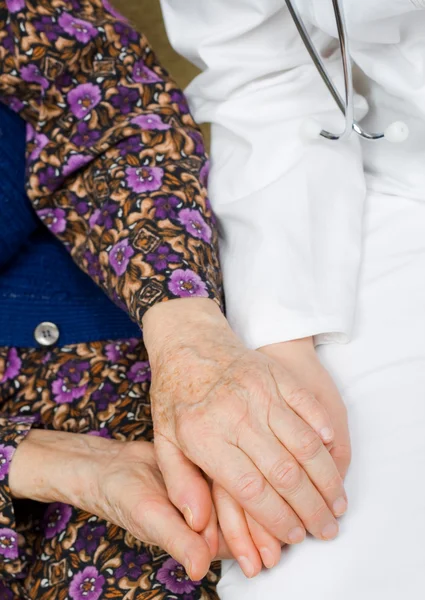 Elderly woman holds the doctor — Stock Photo, Image