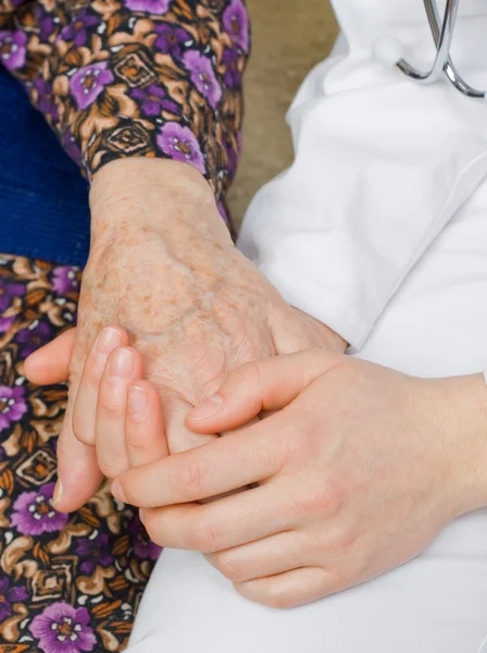 De arts bezit is van een oudere vrouw hand. — Stockfoto