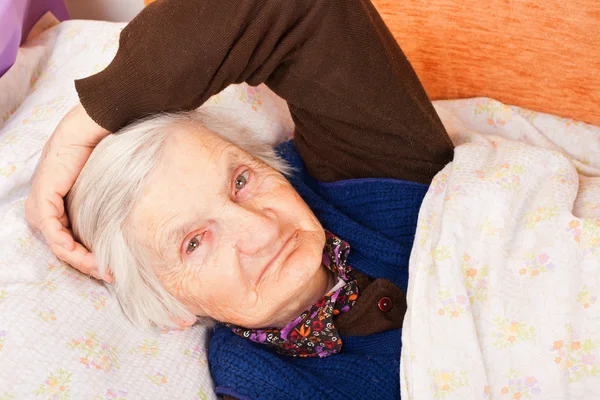 Äldre ensam kvinna vilar i sängen — Stockfoto