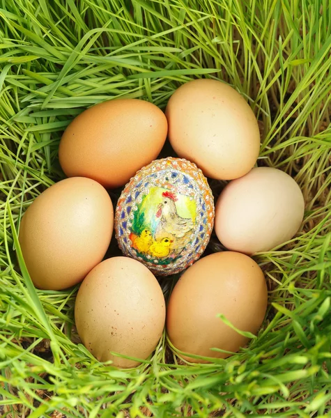 Цветное яйцо между неокрашенными яйцами — стоковое фото