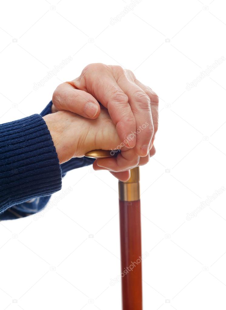 Elderly hands resting on stick
