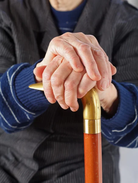 Oudere handen rustend op stok — Stockfoto