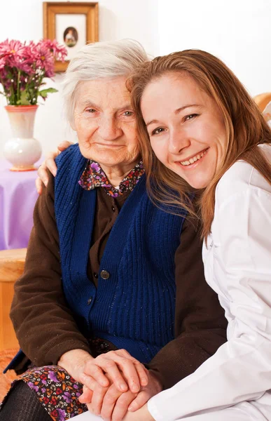 Young doctor holds the elderly woman hands — Stock Photo, Image