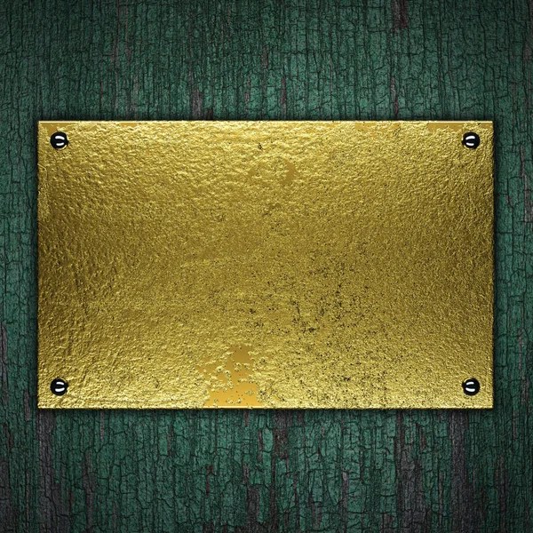 Placa de metal dourado no fundo de madeira. Modelo para design — Fotografia de Stock