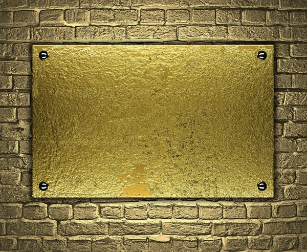 Gold metal plate on brick wall — Stock Photo, Image