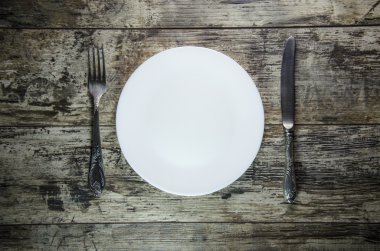 bıçak ve çatal ahşap masa üzerinde beyaz tabaklar