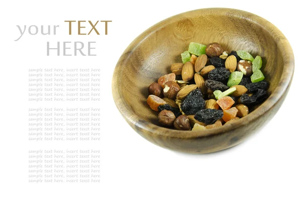 Nuts and dried fruit in a wooden bowl isolated on white. — Stock Photo, Image