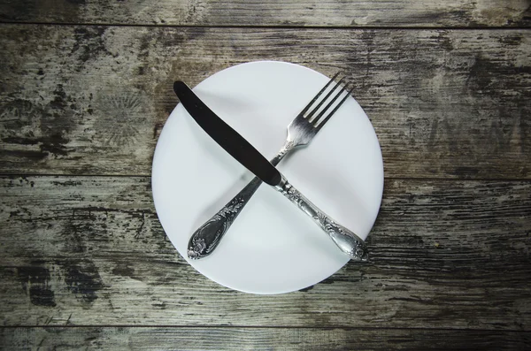 Placas brancas com faca e garfo na mesa de madeira — Fotografia de Stock