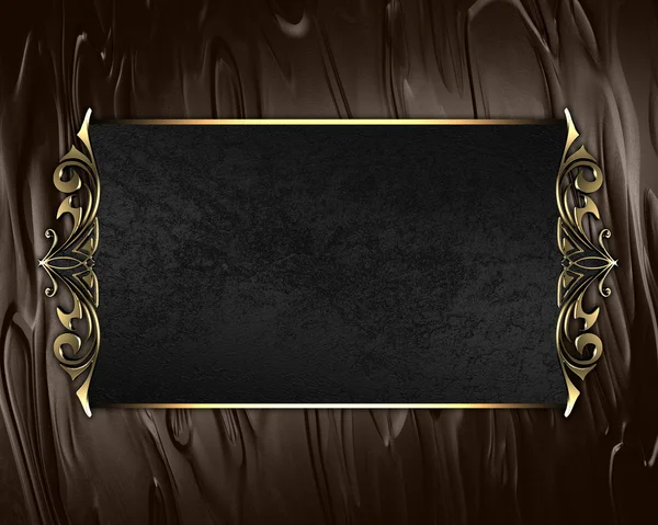 Placa de nome preto com bordas ornamentadas de ouro, sobre fundo marrom — Fotografia de Stock