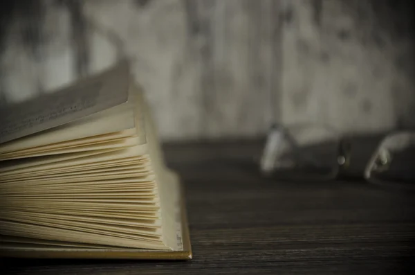 Вінтажна книга, відкрита, на старому дерев'яному столі, з відсічним контуром — стокове фото