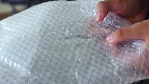 Man Bursts Bubbles Packaging Bubble Wrap — Stock Video