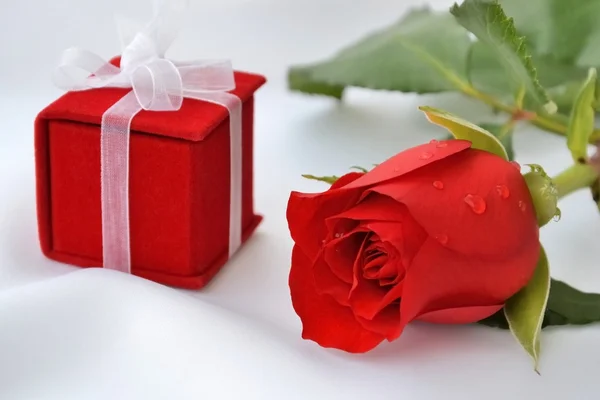 Rosa roja y caja de regalo roja en seda blanca —  Fotos de Stock