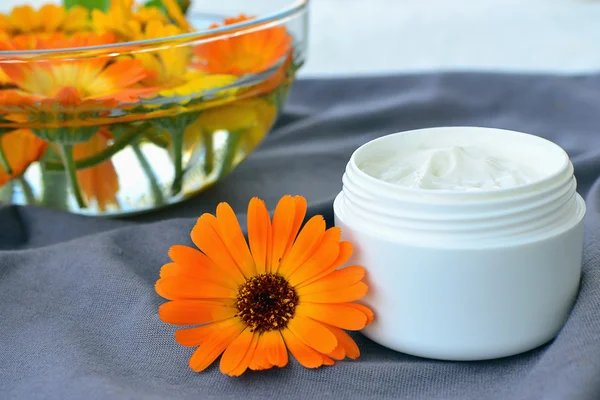 Calendula cosmetic cream and flowers — Stock Photo, Image