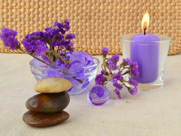 Candle and purple flowers — Stock Photo, Image