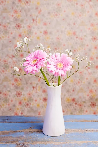 Tahta masadaki vazoda çiçeklerin yakın çekimi. 