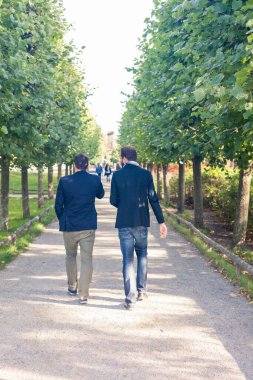 Parkta yürüyen iki işadamı.