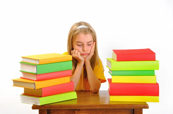 Onderwijs - meisje mokkend onder sommige boeken, geïsoleerd op wit — Stockfoto