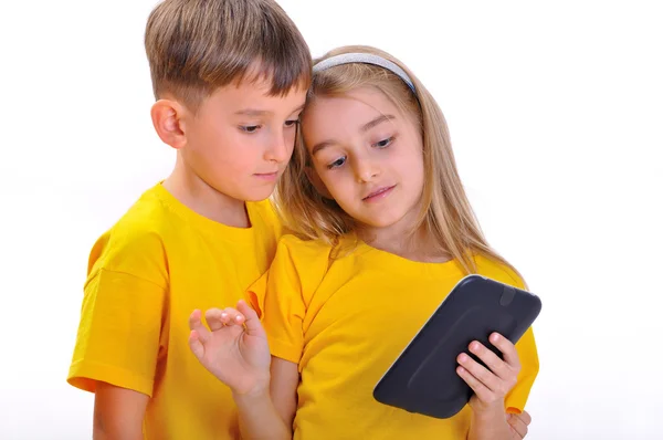 Мальчик и девочка просматривают электронную книгу Лицензионные Стоковые Изображения