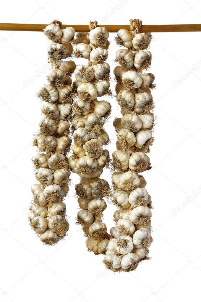 Braids of garlic hanging on a wooden pole