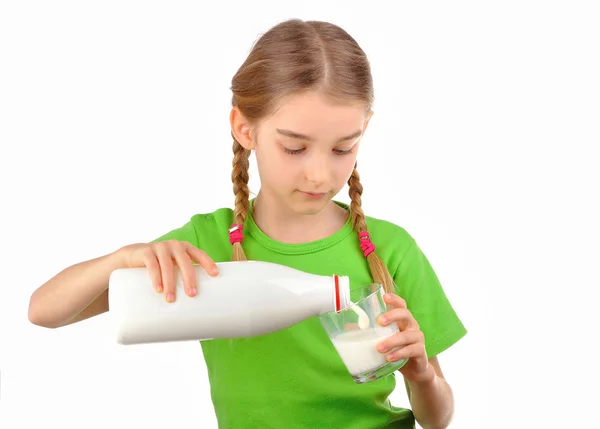 Jolie petite fille verse du lait d'une bouteille dans du verre Image En Vente