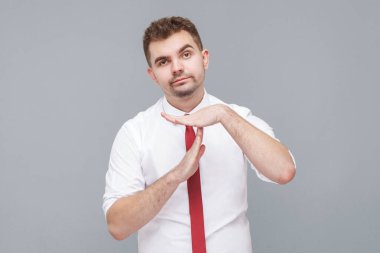 Mola. Beyaz gömlekli ve kravatlı genç bir adamın portresi ciddi bir yüz ifadesiyle kameraya bakıyor. Gri arkaplanda kapalı alan.