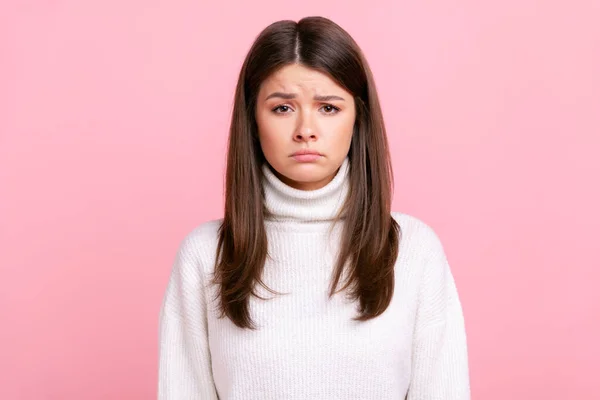 不幸な悲しいブルネットの女性の肖像画は カメラを見て 悲しみを表現し 悪いニュースに動揺され 白いカジュアルなスタイルのセーターを着ている ピンクの背景に隔離された屋内スタジオショット — ストック写真