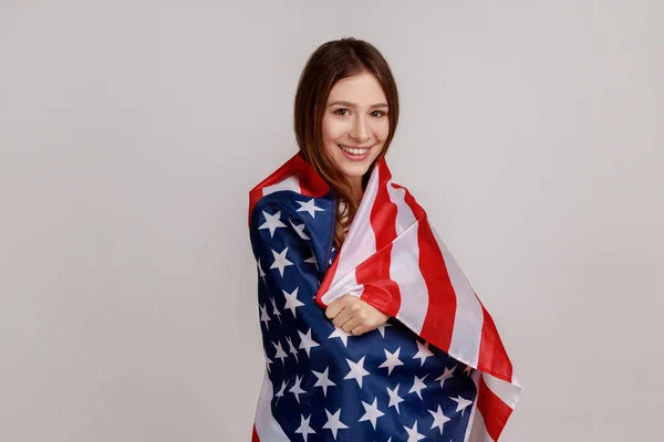 Portret Przyjaznej Młodej Kobiety Stojącej Zawinięty Amerykańską Flagę Patrzącej Kamerę — Zdjęcie stockowe
