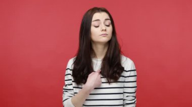 Kendine güvenen esmer kadının portresi kendini işaret ediyor, başarılarıyla övünüyor, egoizmle övünüyor, gündelik tarz uzun kollu gömlek giyiyor. Kırmızı arkaplanda kapalı stüdyo çekimleri.