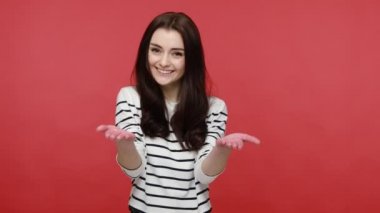Esmer, mutlu bir kadının portresi kucaklaşmak için ellerini ardına kadar açıyor, dostunu selamlıyor, sevgisini paylaşıyor, gündelik tarzda uzun kollu gömlek giyiyor. Kırmızı arkaplanda kapalı stüdyo çekimleri.