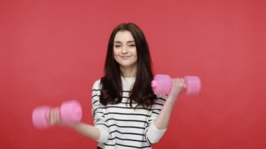 Komik çocuksu kadın portresi pembe dambıllar kaldırıyor komik bir ifadeyle, helatif bir yaşam tarzıyla..