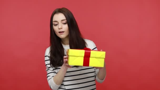 호기심많은 상자를 선물에 만족하고 평상복 스타일의 셔츠를 배경으로 스튜디오 — 비디오