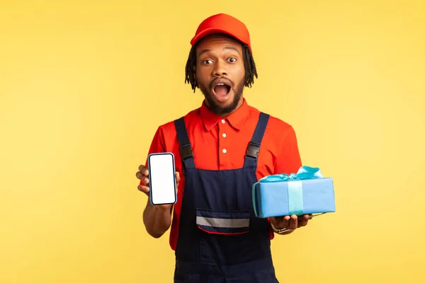 Porträt Eines Überraschten Kuriers Blauer Uniform Der Geschenkboxen Und Smartphone — Stockfoto