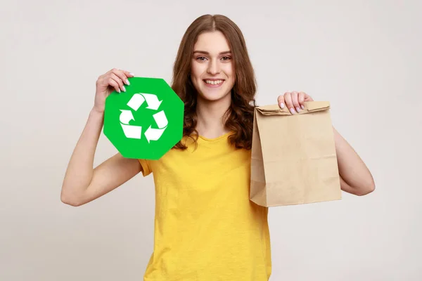 Glimlachend Tienermeisje Met Geel Shirt Met Papieren Pakje Groen Recyclingbord — Stockfoto