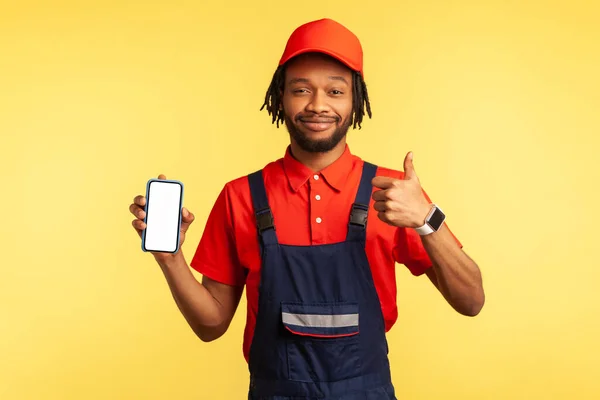 Zadowolony Złota Rączka Noszenie Kombinezonów Trzymając Smartfon Pustym Ekranem Reklamy — Zdjęcie stockowe
