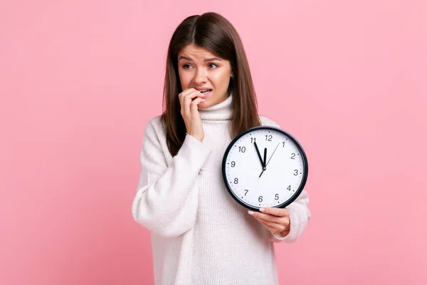 Retrato Morena Nerviosa Joven Mujer Sosteniendo Gran Reloj Pared Mordiendo — Foto de Stock