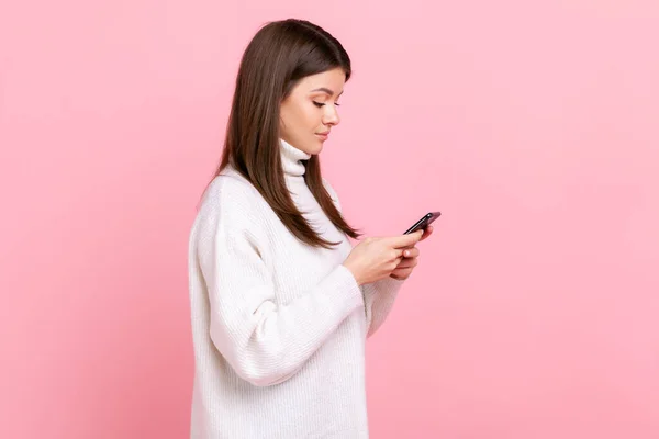 스마트폰을 사용하고 네트워크를 확인하는 여성의 사진은 흰색의 캐주얼 스타일 스웨터를 — 스톡 사진