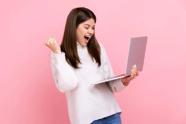 노트북을 주먹을 성공을 축하하고 흰색의 평상복 차림의 스웨터를 행복하게 소리를 — 스톡 사진