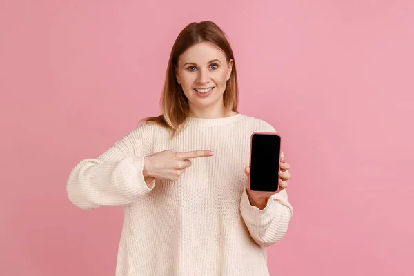 Retrato Mulher Satisfeita Segurando Telefone Inteligente Nas Mãos Apontando Para — Fotografia de Stock