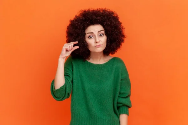 스타일의 여자가 초록색 스웨터를 손가락으로 크기의 동작을 카메라를 모습이다 스튜디오는 — 스톡 사진
