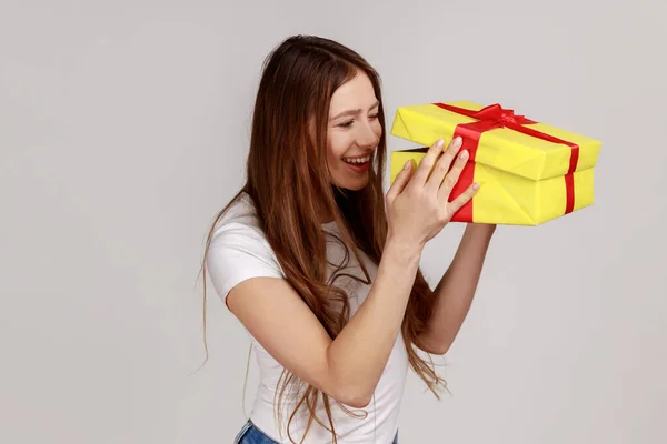 Mazaná Žena Tmavými Vlasy Rozbaluje Žlutou Dárkovou Krabici Dívá Dovnitř — Stock fotografie