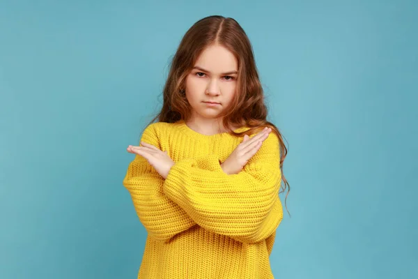 少女の手を渡り 侵略とカメラを見て 停止ジェスチャーを示す方法を禁止し 黄色のカジュアルなスタイルのセーターを着ている 青い背景に隔離された屋内スタジオショット — ストック写真