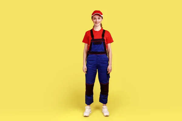 Ayakta Duran Kameraya Pozitif Yüz Ifadesiyle Bakan Tulumlu Kırmızı Şapkalı — Stok fotoğraf