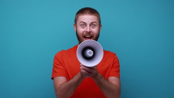 Ein Bärtiger Mann Mit Orangefarbenem Shirt Schreit Laut Megafon Verkündet — Stockvideo